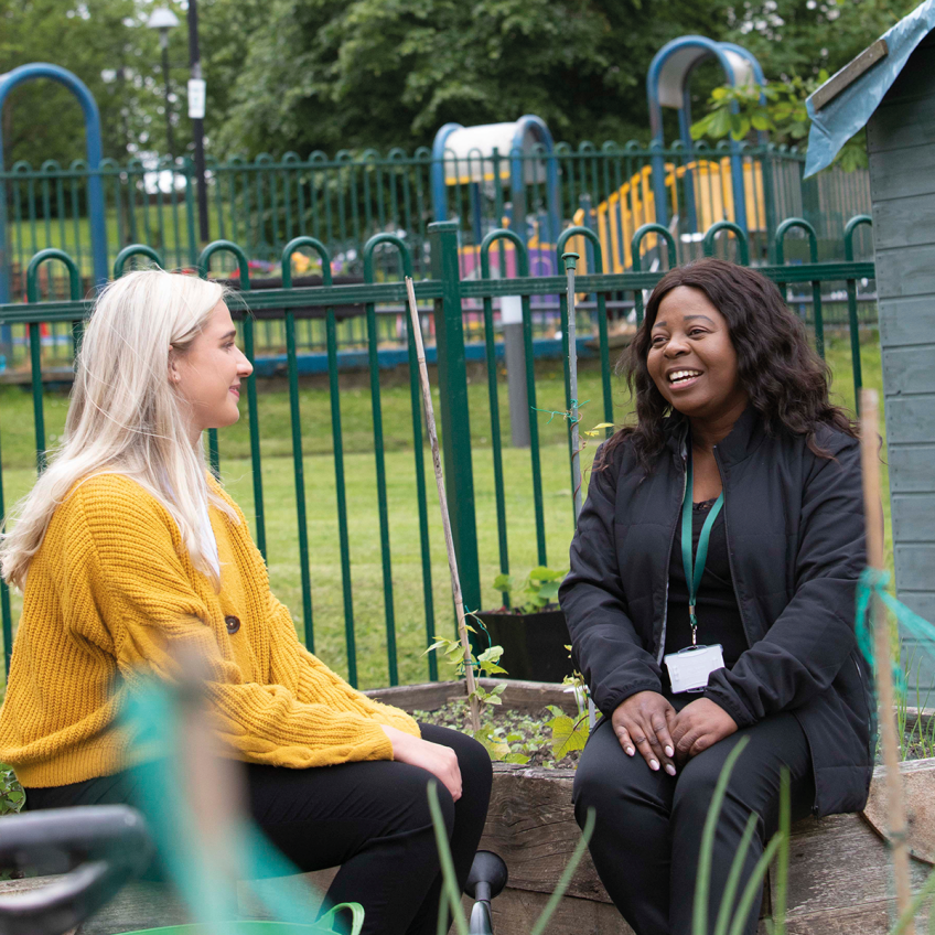 Image of two Wheatley Care staff talking on a bench